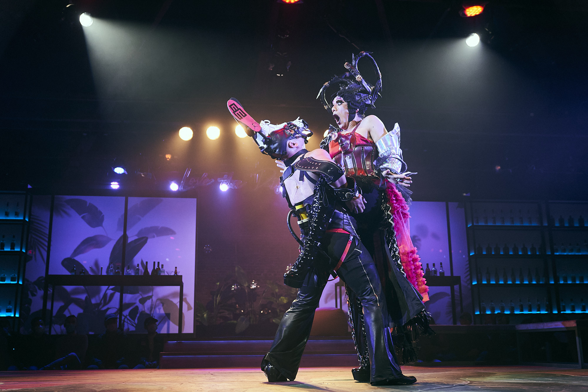 Duo in elaborate costumes under purple light