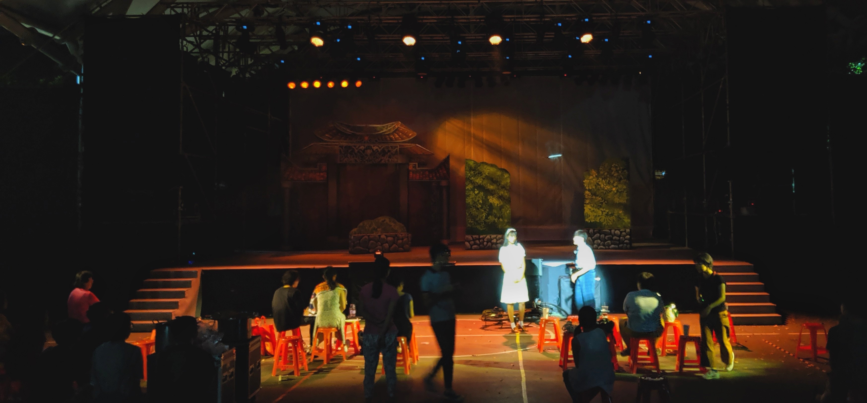 Outdoor stage with warm lighting and audience