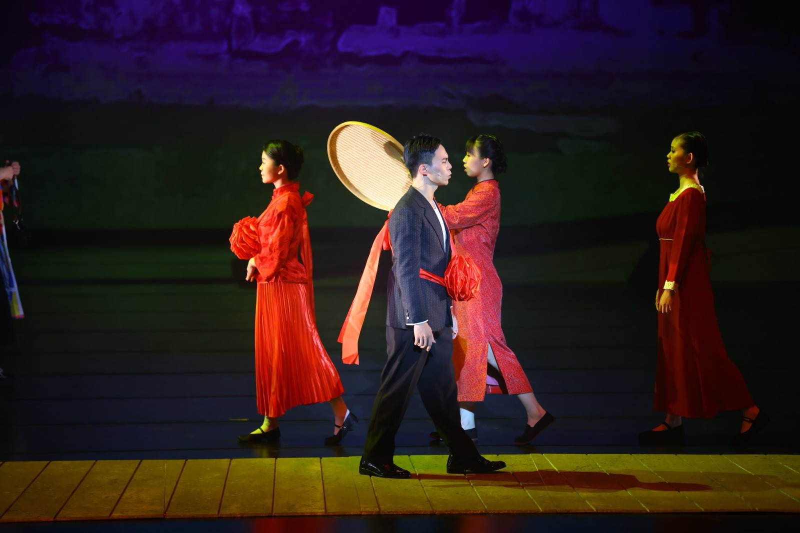 Procession with red dresses and bamboo hat against landscape projection