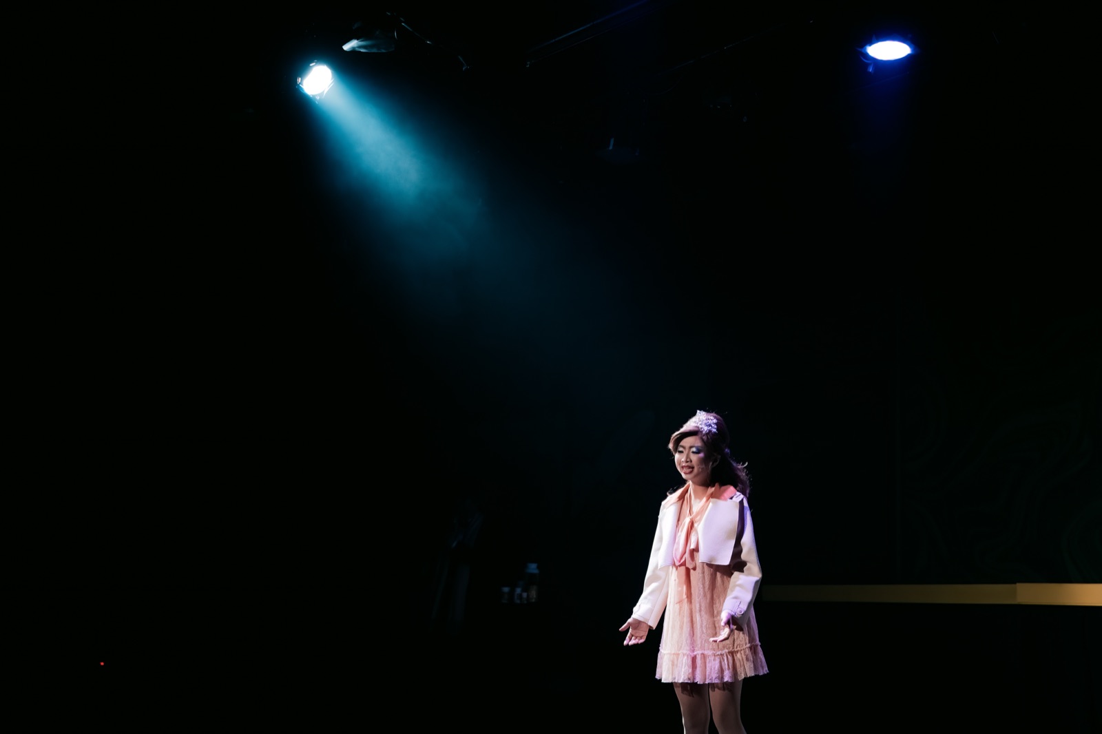 Woman solo under teal spotlight