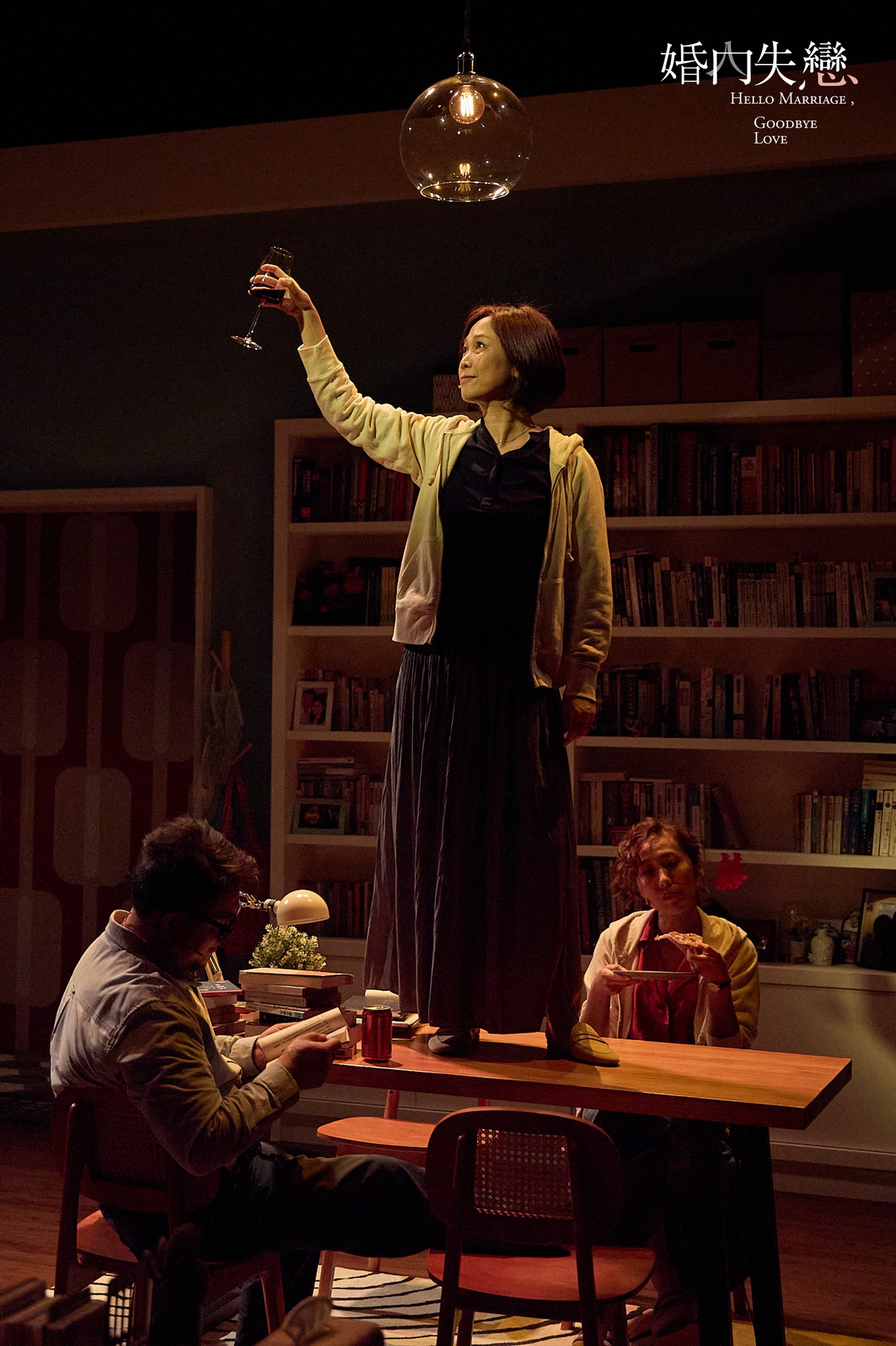 Woman raising wine glass under pendant light