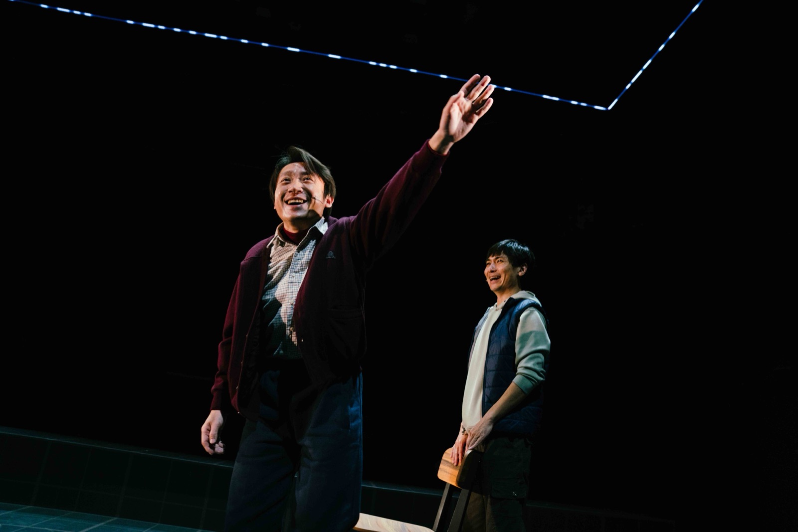 Two men smiling with LED line above