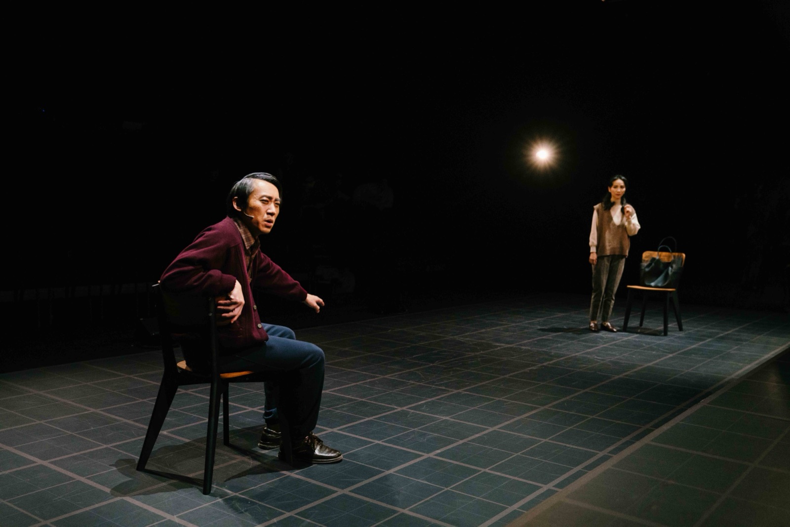 Man on chair with woman standing in distance