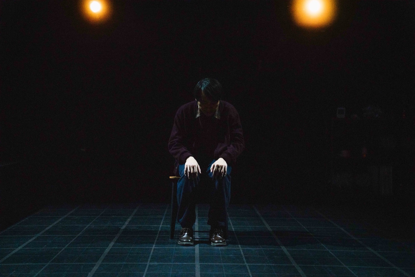 Man sitting alone on chair with head down