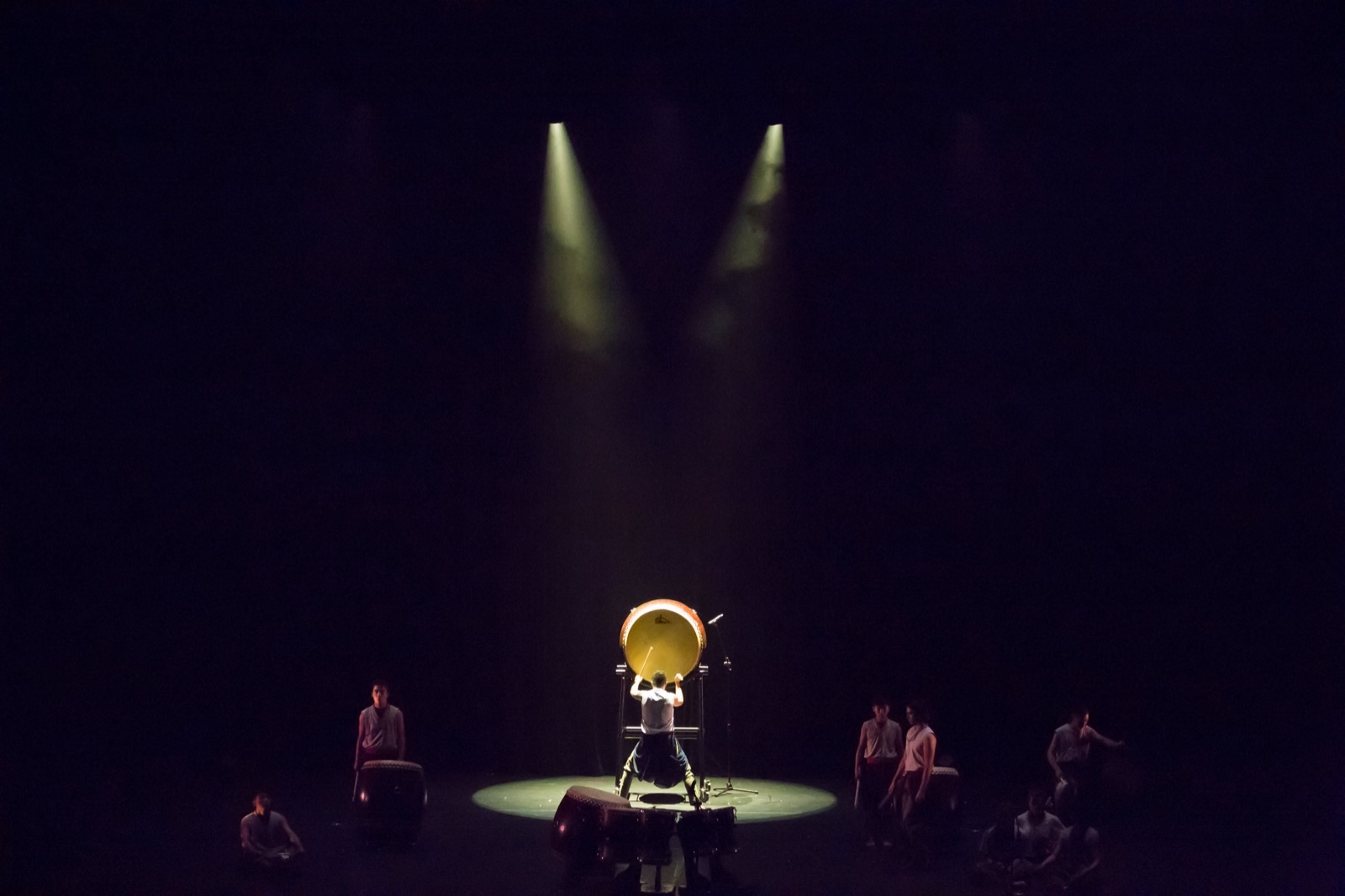 Solo drummer in warm spotlight