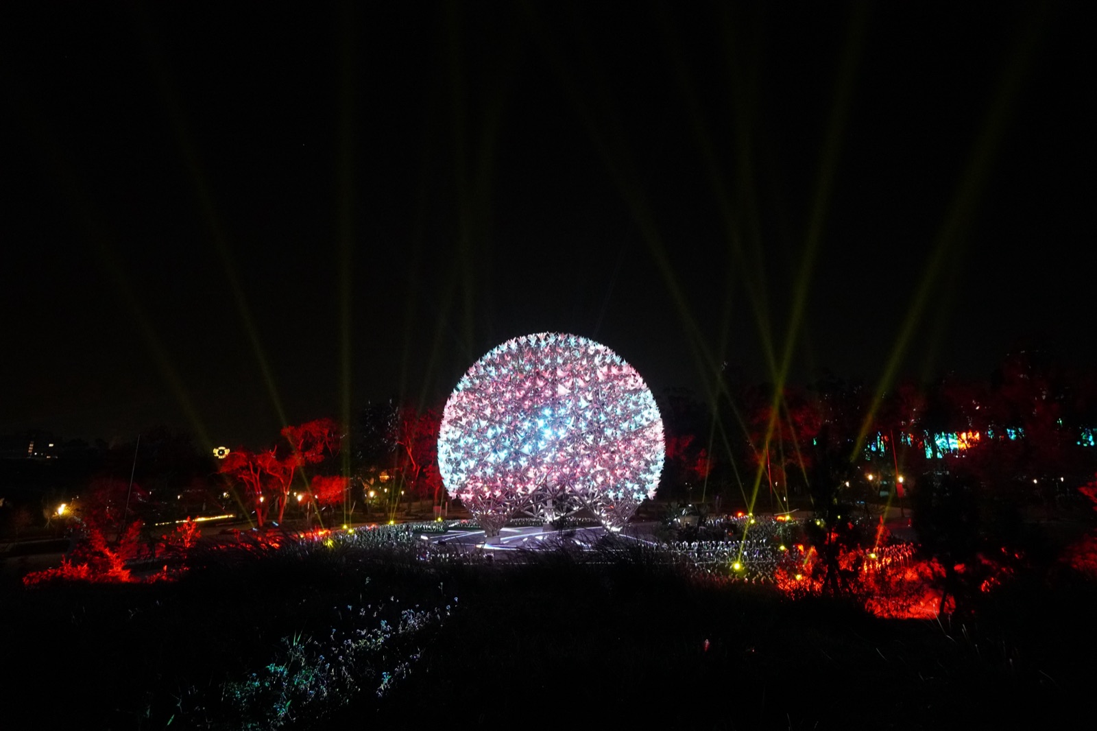 Sphere blooming pink-white with red-lit surrounding landscape