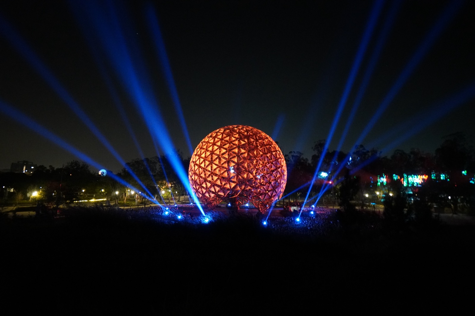 Sphere in warm red with blue beams extending outward