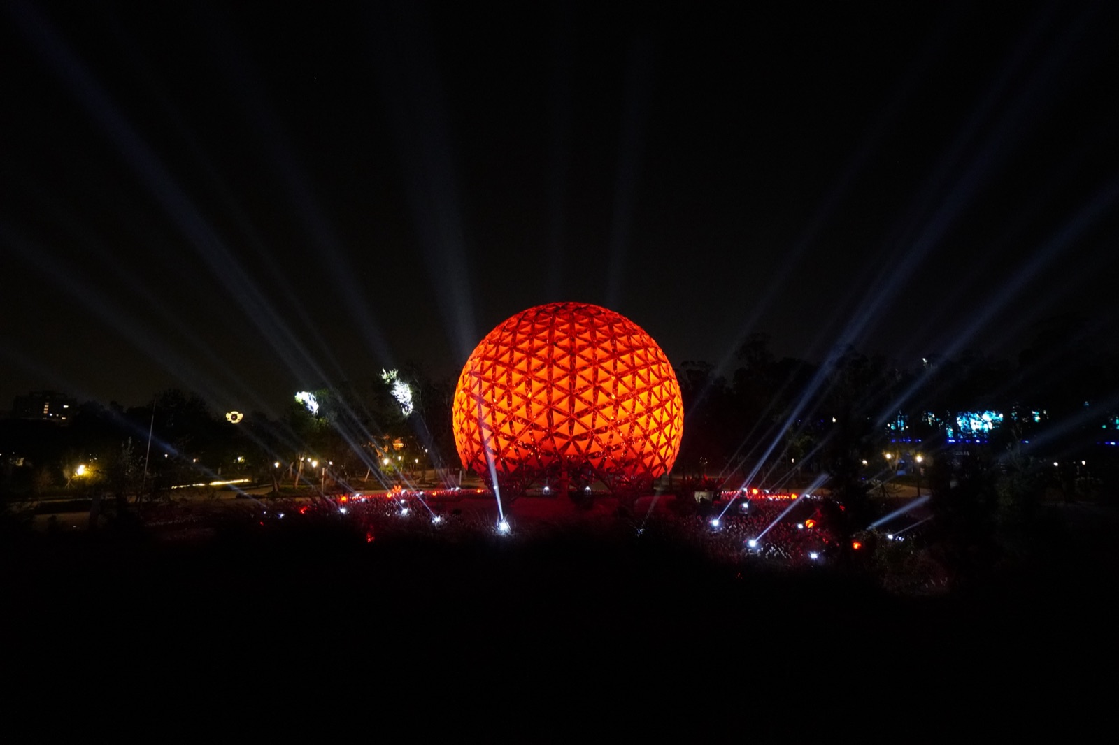 Sphere in red-orange with white beams cutting through darkness
